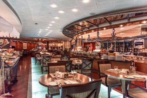 a restaurant with tables and chairs and a bar at Roda Al Murooj Residences in Dubai
