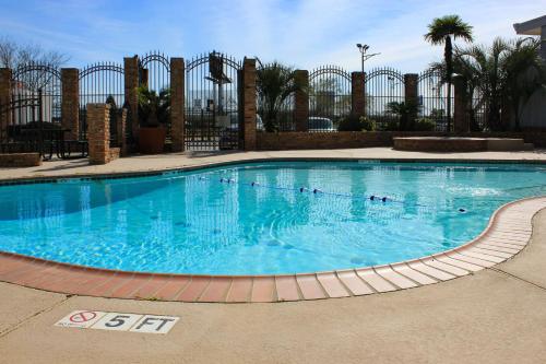 a large swimming pool with blue water in a resort at Studio 6-Houston, TX - East in Houston