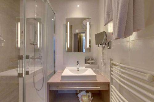 a white bathroom with a sink and a shower at Best Western Hôtel d'Arc in Orléans