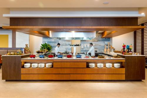 una cocina con dos chefs que preparan comida en un restaurante en Hyatt Regency Cartagena, en Cartagena de Indias