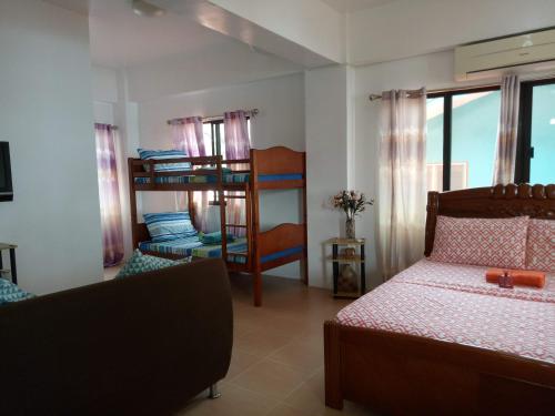 a bedroom with a bed and bunk beds in it at SmallFry's Beach Resort in Calatrava