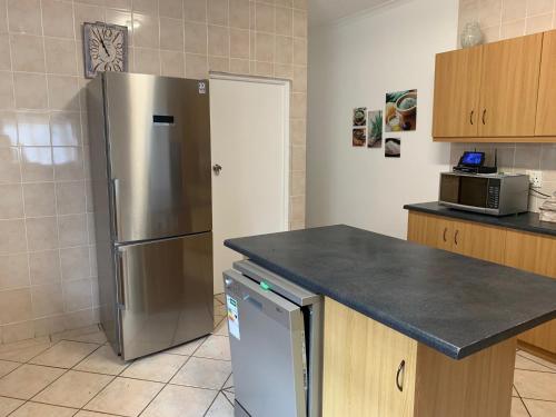 a kitchen with a stainless steel refrigerator and a counter at Sea Jewel in Pearly Beach
