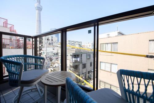 a balcony with chairs and a table and a large window at SOLA HOTEL in Tokyo