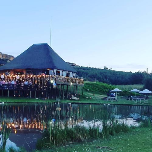 a large building with a lot of lights in front of a lake at Cheetau Lodge in Ebenhaezer