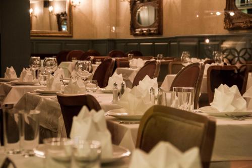 a dining room with white tables and chairs with napkins at Hotel Gritti Pera & Spa in Istanbul
