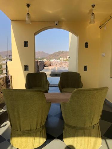 a table and chairs in a room with a view at Jai Villa Homestay in Udaipur