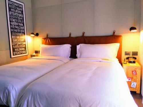 two beds sitting next to each other in a room at Just Sleep - Sanchong in Taipei