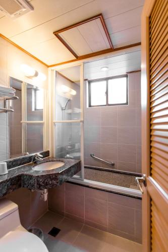 a bathroom with a sink and a shower at Hub Hotel Ximen-inn Kunming in Taipei