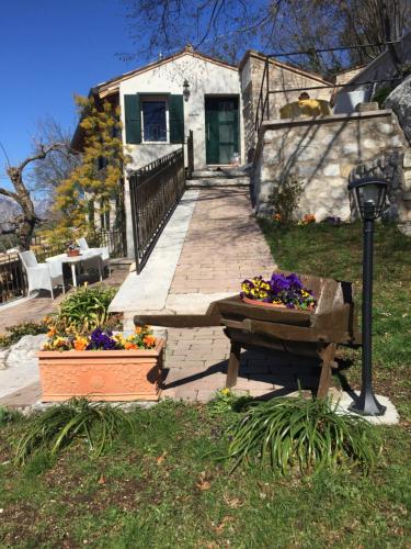 a house with a bench and flowers in front of it at Mansardino in Malcesine