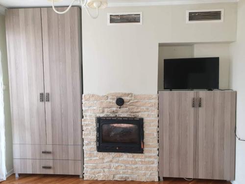 sala de estar con chimenea de ladrillo y TV en Kalina apartment, en Ruse