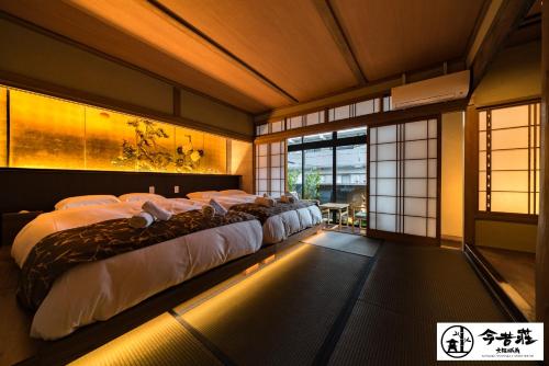 a bedroom with four beds in a room with windows at Konjaku-So Osaka Castle South in Osaka