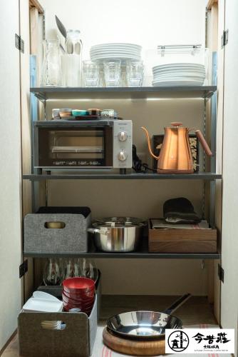 a kitchen pantry with dishes and a toaster oven at KONJAKUSO Osaka Tsuruhashi "KAKUJU" in Osaka