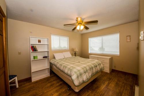 Schlafzimmer mit einem Bett und einem Deckenventilator in der Unterkunft Meadow Mountain Home in Garden City