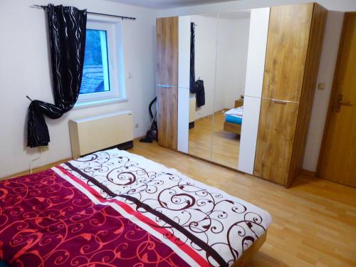 een slaapkamer met een bed en een grote spiegel bij Ferienwohnung zum Pinguin in Wiednitz