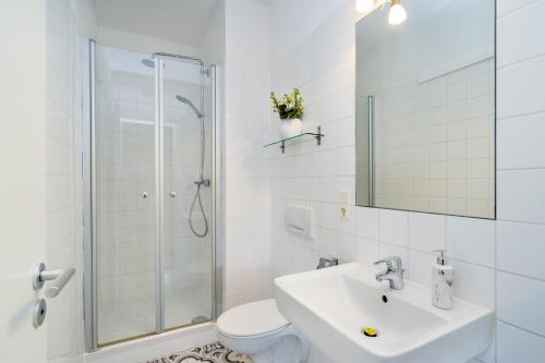 a bathroom with a shower and a sink and a toilet at GreatStay Apartment - Melchiorstr. in Berlin