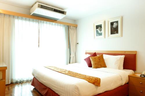 Un dormitorio con una cama grande con una ventana grande. en Chaidee Mansion, en Bangkok