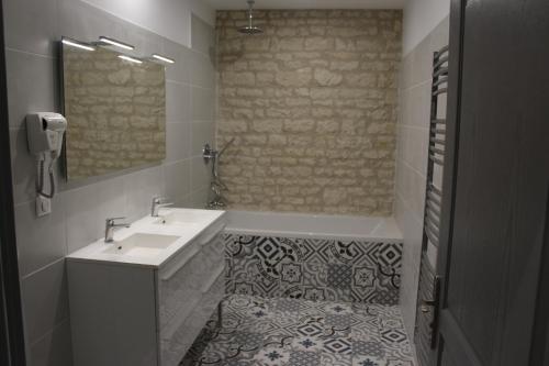 a bathroom with a sink and a tub and a mirror at Château des Loups - Les Pommiers in Échiré