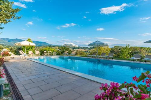 a large swimming pool with chairs and umbrellas at Relais Villa Al Vento in Incisa in Valdarno