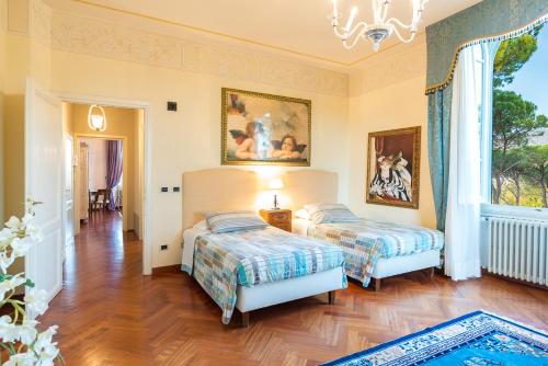 a bedroom with two beds and a chandelier at Relais Villa Al Vento in Incisa in Valdarno