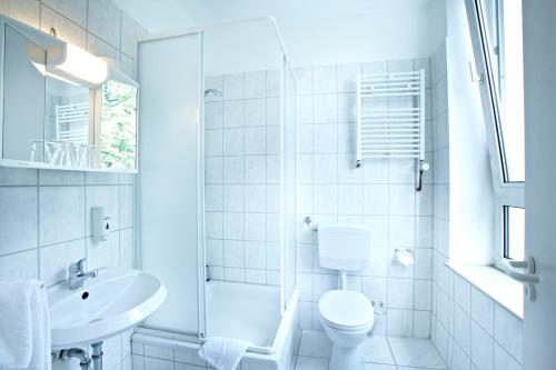 a white bathroom with a toilet and a sink at Hotel Liegeplatz 13 Kiel by Premiere Classe in Kiel