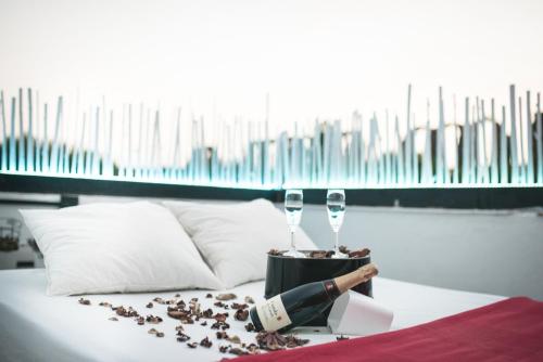 a table with two wine glasses on a bed at La abuela Pepa Fácil Aparcamiento in Mérida