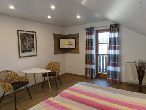 a bedroom with a bed and a table and chairs at Privatpension Eberth in Bogen