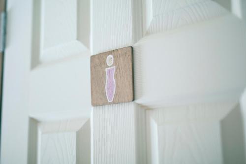 a door with a pink toothbrush sign on it at Otaru Tap Room & Hostel in Otaru