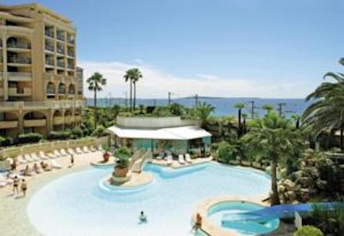 una grande piscina in un resort con persone di Cannes Front Beach Pools Apartment a Cannes