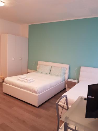 a bedroom with two beds and a table and a desk at B&B Porto Vecchio ROOMS - Stazione Centrale Trieste in Trieste