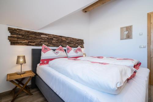 um quarto com uma cama grande e almofadas vermelhas e brancas em Pistenblick em Sankt Margarethen im Lungau