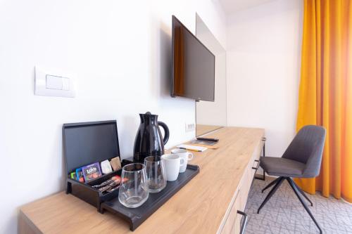 a room with a desk with a television and a chair at City Inn in Pristina