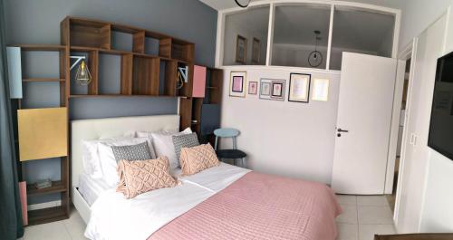 a bedroom with a white bed with a pink blanket at Cozy Getaway in Nicosia in Yukarı Lakatamya