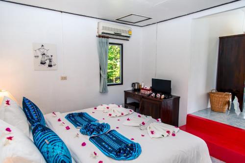 a bedroom with a bed and a desk and a window at Zama Resort Koh Phangan in Haad Chao Phao