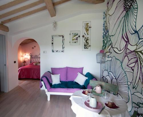 バルベリーノ・ディ・ヴァル・デルサにあるLa Casina di Cioccolataの紫色のソファとベッド付きのリビングルーム