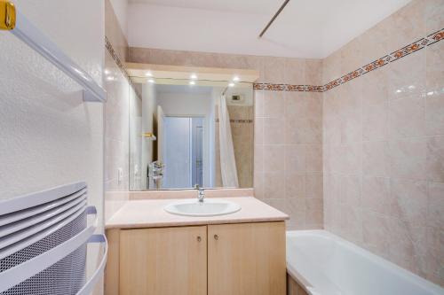 a bathroom with a sink and a bath tub at Vacancéole - Les Calanques Du Parc in Saint-Aygulf