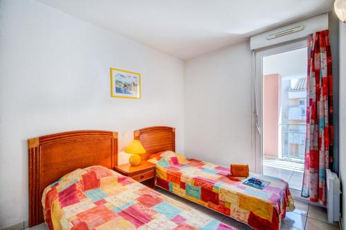 - une chambre avec 2 lits et une fenêtre dans l'établissement Vacancéole - Les Calanques Du Parc, à Saint-Aygulf