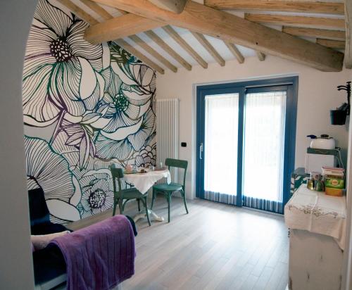 una sala de estar con una mesa y un mural de flores en la pared en La Casina di Cioccolata, en Barberino di Val d'Elsa