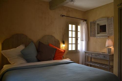 ein Schlafzimmer mit einem großen Bett und einem Fenster in der Unterkunft La Maison de Moustiers in Moustiers-Sainte-Marie