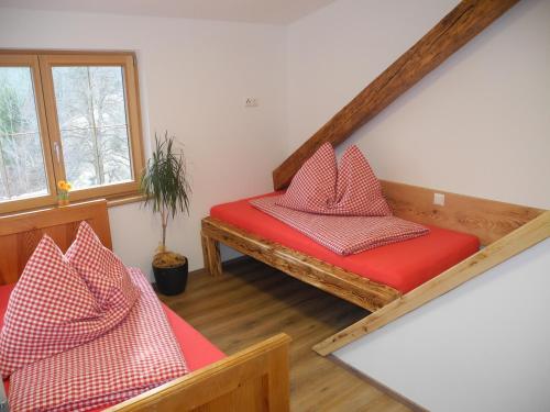 ein Zimmer mit zwei Bänken mit roten Kissen darauf in der Unterkunft Entschleunigungshof Huberbauer in Kötschach