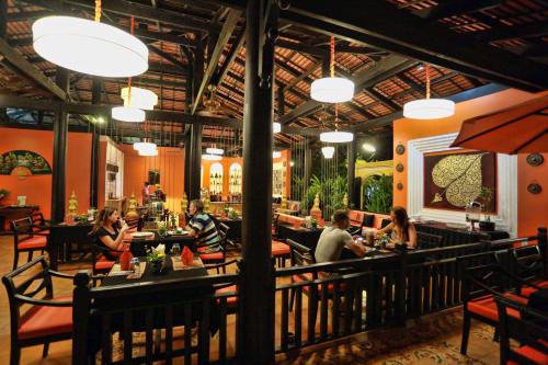 a group of people sitting at tables in a restaurant at Residence Indochine D'angkor in Siem Reap