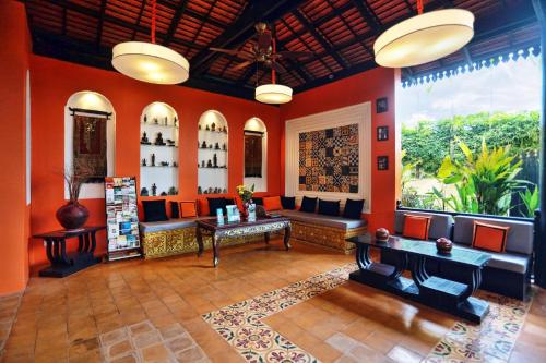 a lobby with orange walls and a table and chairs at Residence Indochine D'angkor in Siem Reap