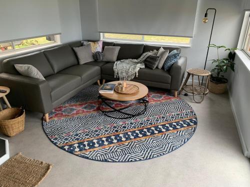 a living room with a couch and a rug at Secret Spot - Bruny Island in Lunawanna