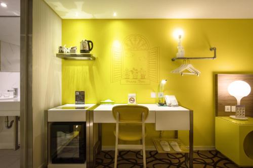 a yellow room with a desk and a chair at Green World Hotel - Zhonghua in Taipei