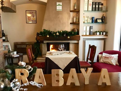 a dining room with a table and a fireplace at Locanda Rabaya' in Barbaresco