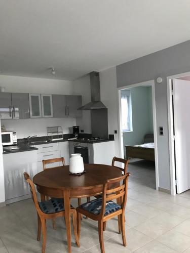 - une cuisine avec une table en bois, 2 chaises et une table dans l'établissement la grange aux hortensias, à Thiergeville