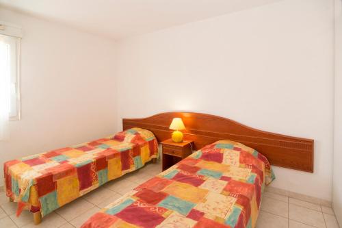 Vacancéole - Résidence Le Palmyra Golf tesisinde bir odada yatak veya yataklar