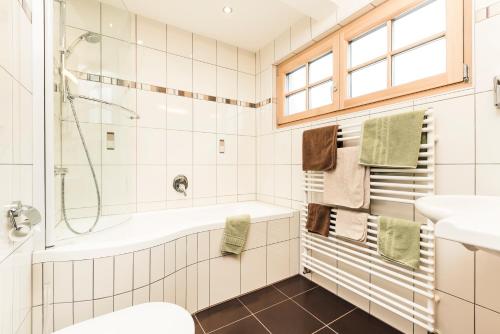 y baño con bañera, ducha y lavamanos. en Madle - B&B, en Sölden