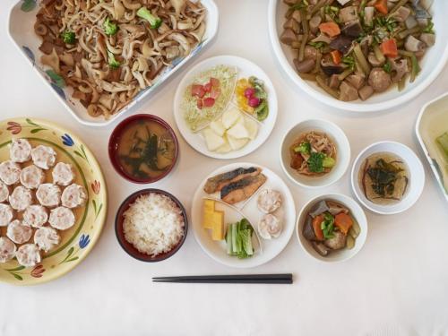 einen Tisch mit Teller mit Lebensmitteln und Schüsseln mit Lebensmitteln in der Unterkunft JR-EAST HOTEL METS HACHINOHE in Hachinohe