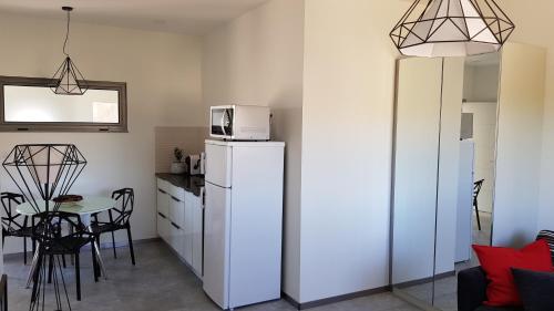 a kitchen with a refrigerator and a table with chairs at צימר גראפה בערבה - Grappa in Yahel