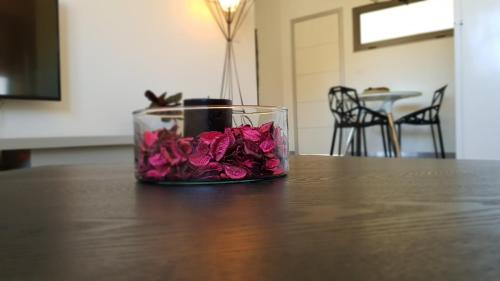 a glass jar filled with pink roses sitting on a table at צימר גראפה בערבה - Grappa in Yahel
